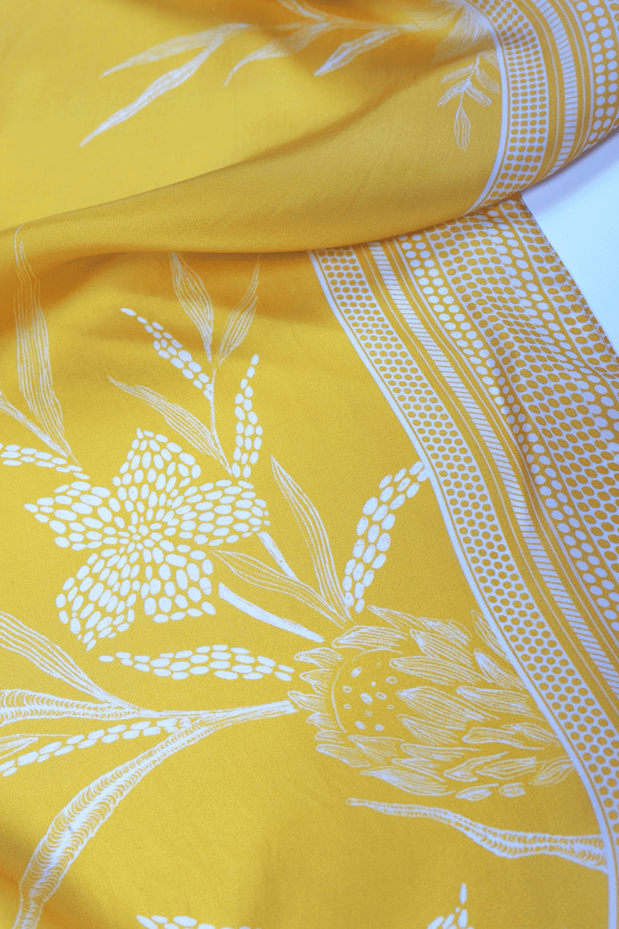 Yellow scarf with white floral and geometric patterns