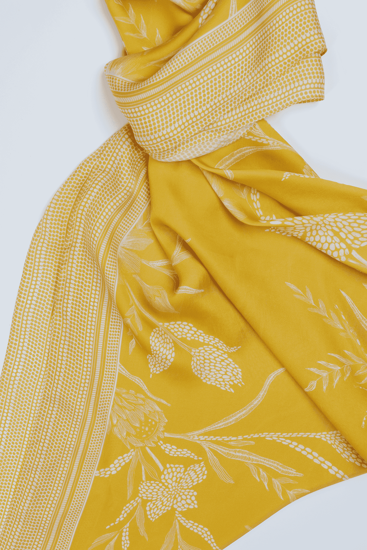 Yellow scarf with white floral patterns on a white background